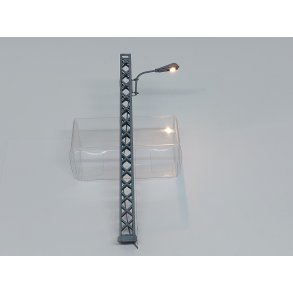 Gittermast i gr med varm hvidt lys